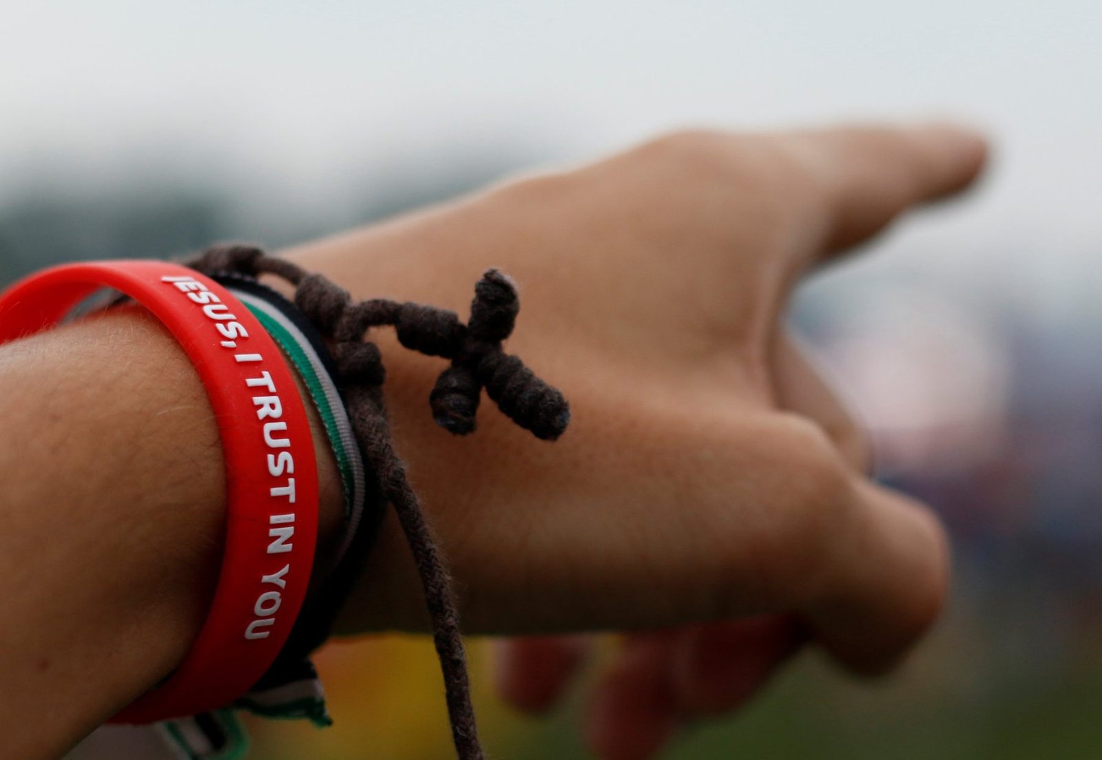 Mano con una cruz de cuerda señalando al horizonte